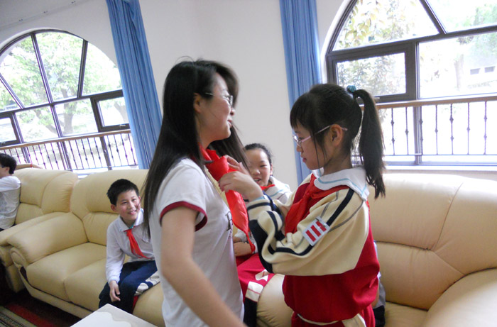 小学生为足球官网志愿者系红领巾